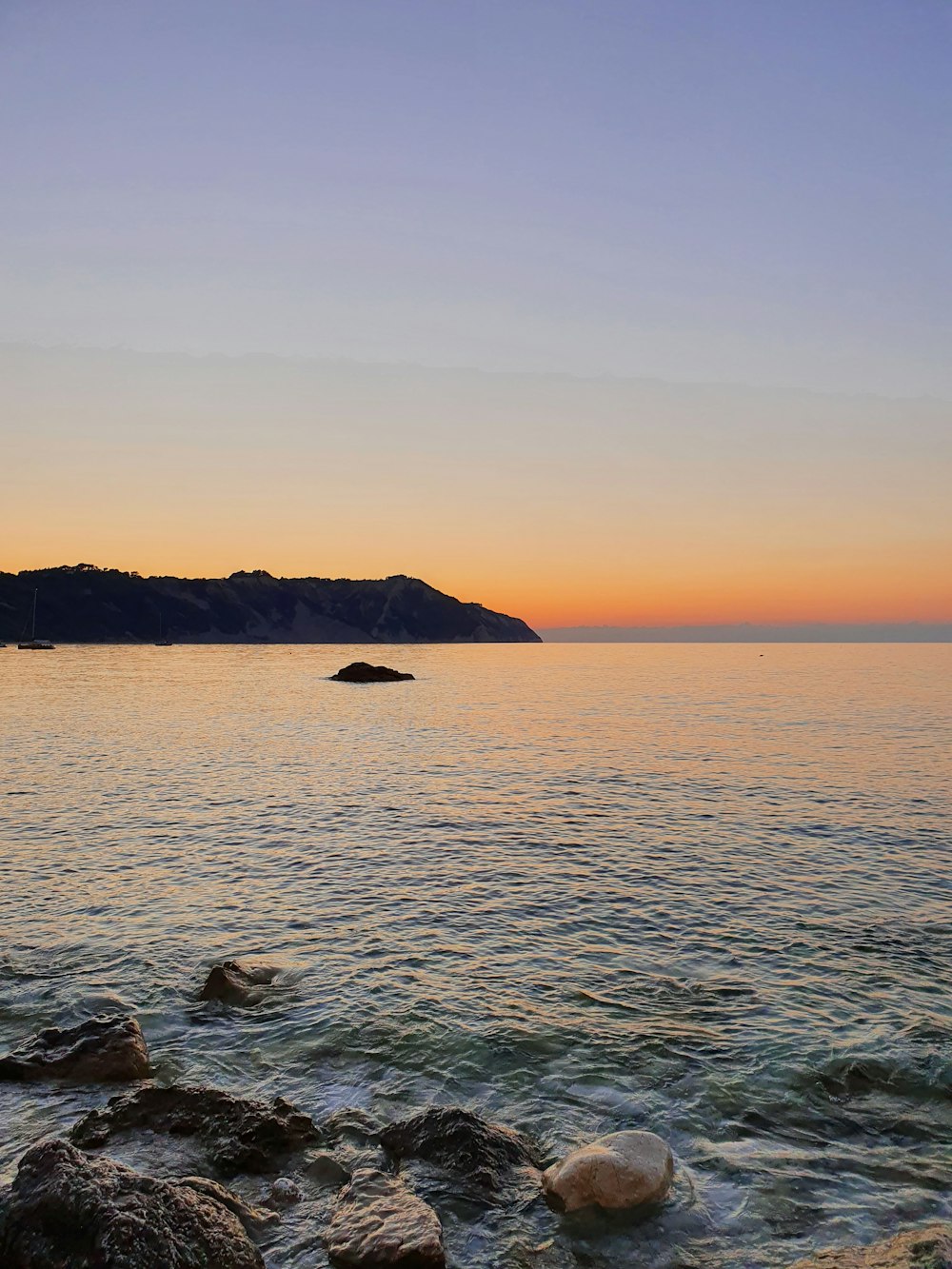 body of water near mountain during daytime