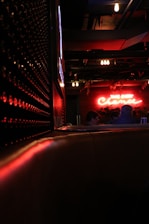 A tasteful, dimly lit scene featuring a cozy lounge setting with soft pink lighting.