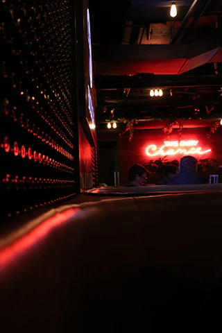 A dimly lit, sleek black and red lounge with gold accents, capturing mysterious nightlife vibes.