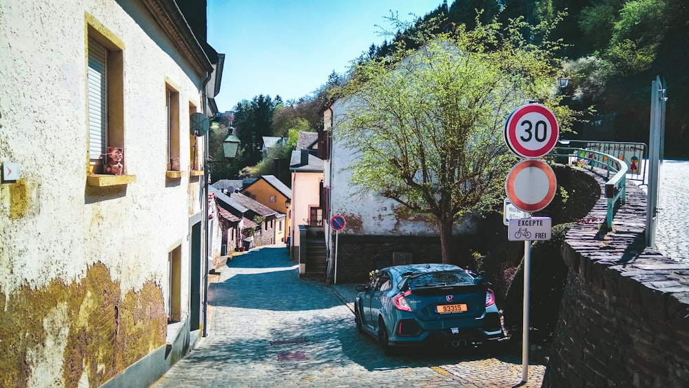 Voiture noire garée à côté d’un bâtiment en béton brun pendant la journée