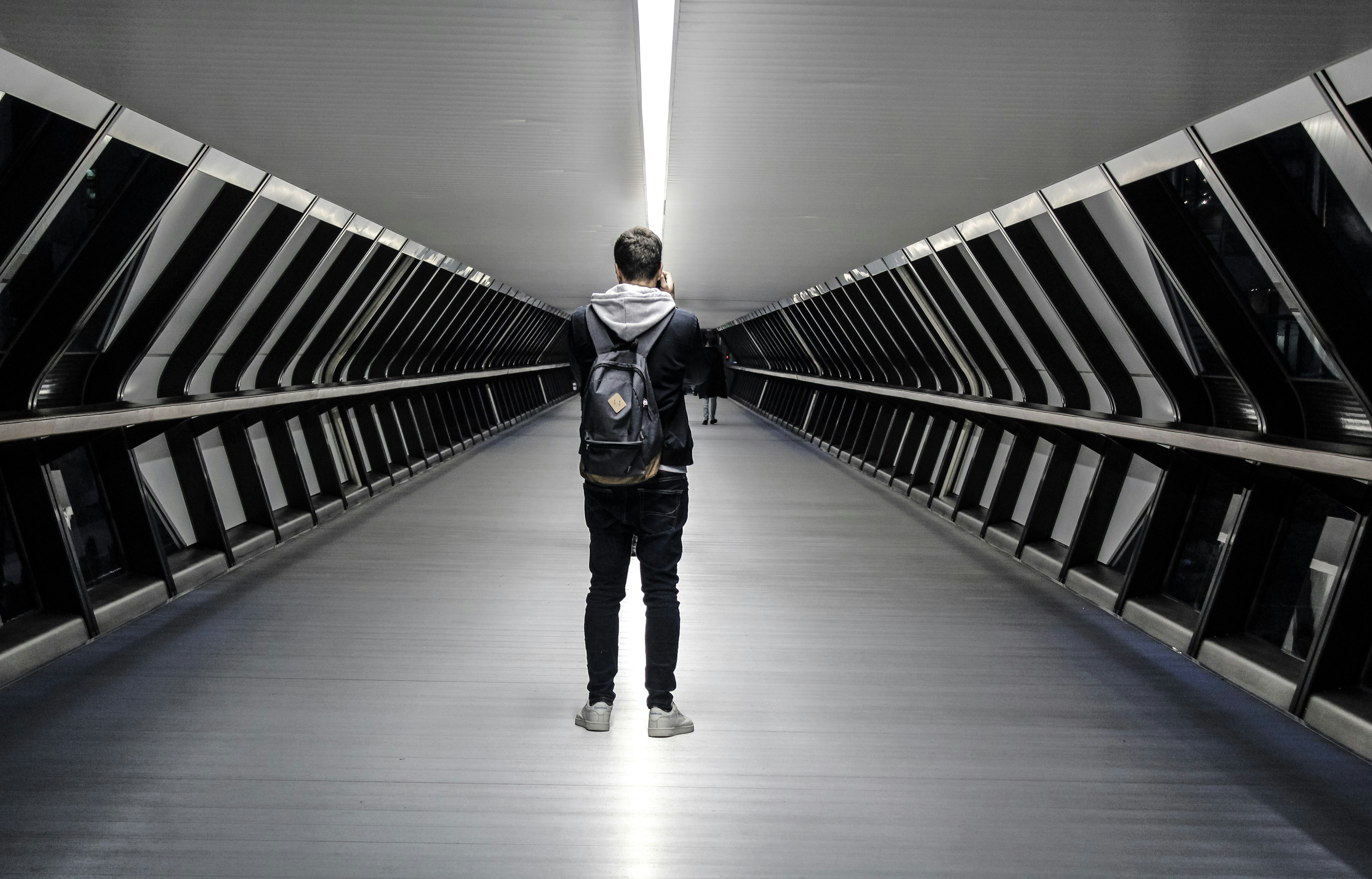 man in black jacket walking on white floor