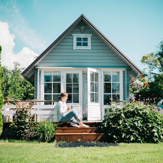 woman in white long sleeve shirt sitting on brown wooden bench in Saaremaa Estonia