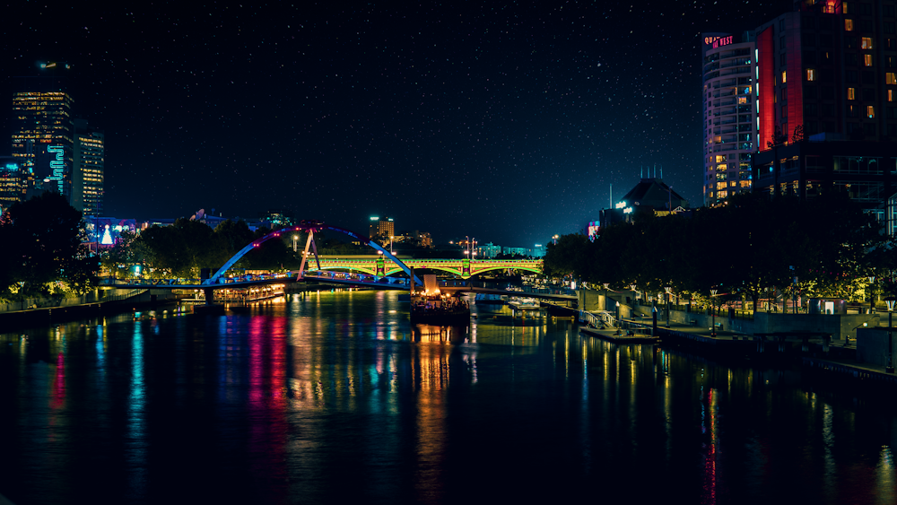 beleuchtete Brücke über den Fluss während der Nachtzeit