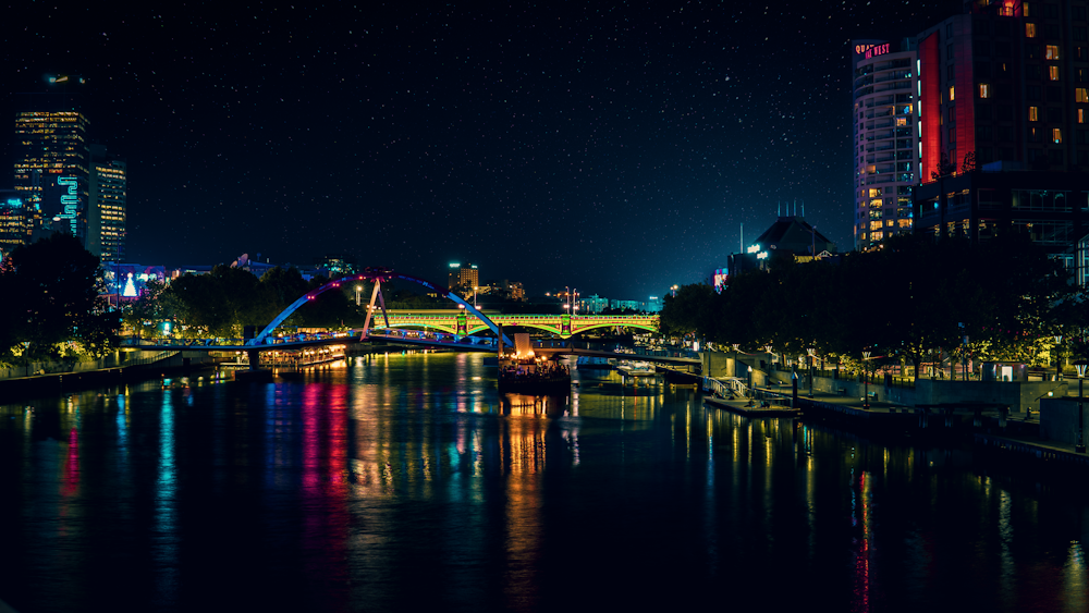 lighted bridge over river during night time