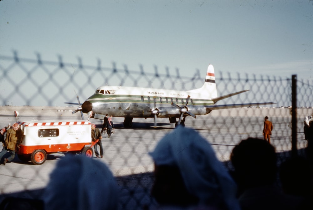 people standing near white airplane during daytime