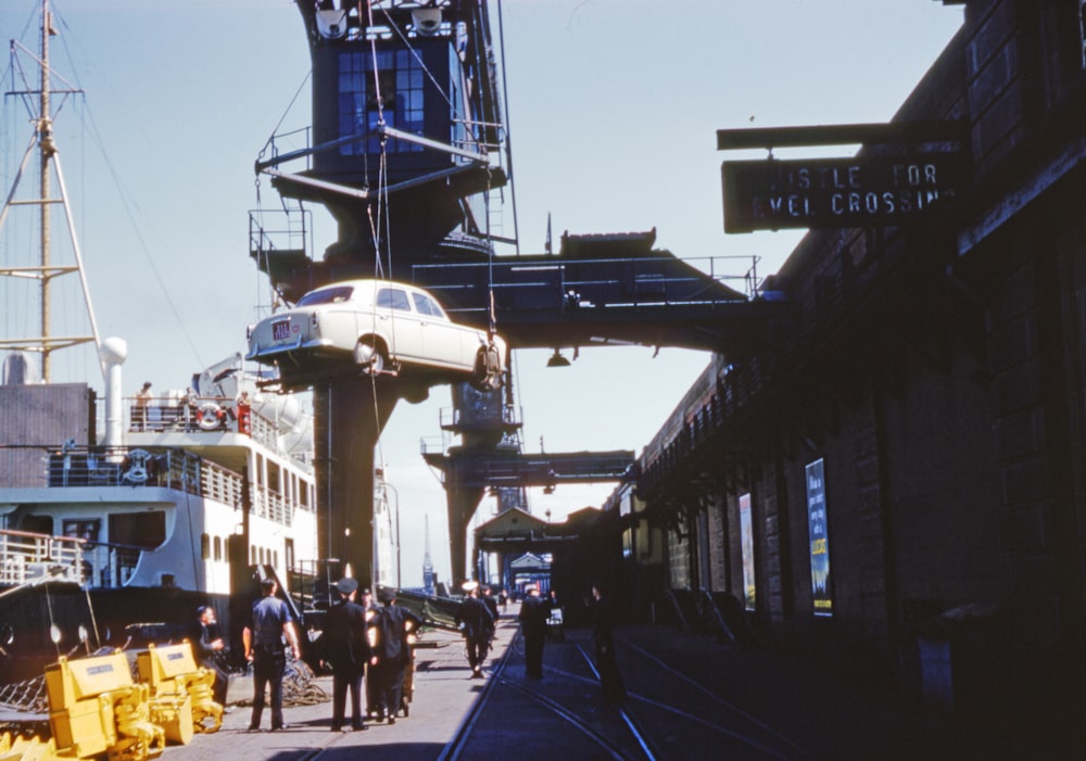 people walking on the street near white and blue ship during daytime