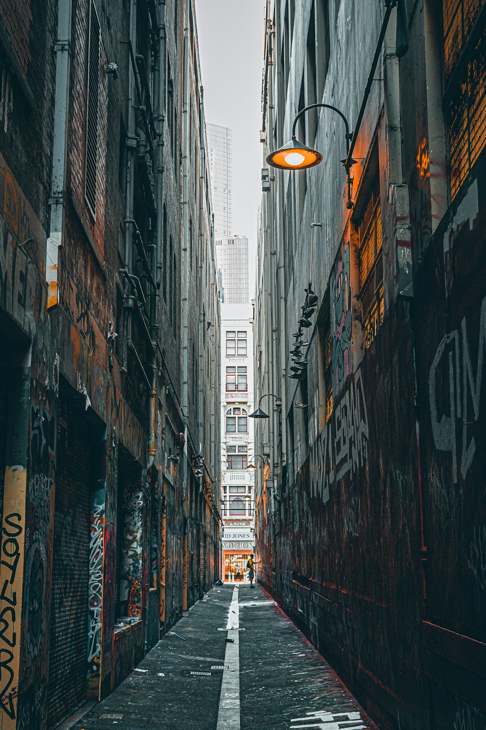 black and white street lamp between buildings during daytime