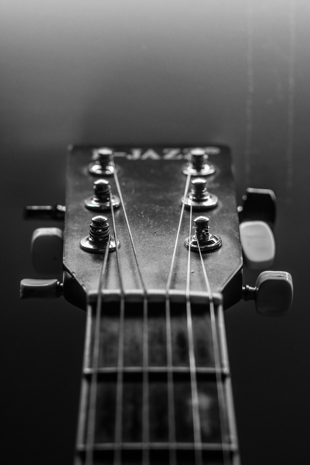 grayscale photo of guitar headstock