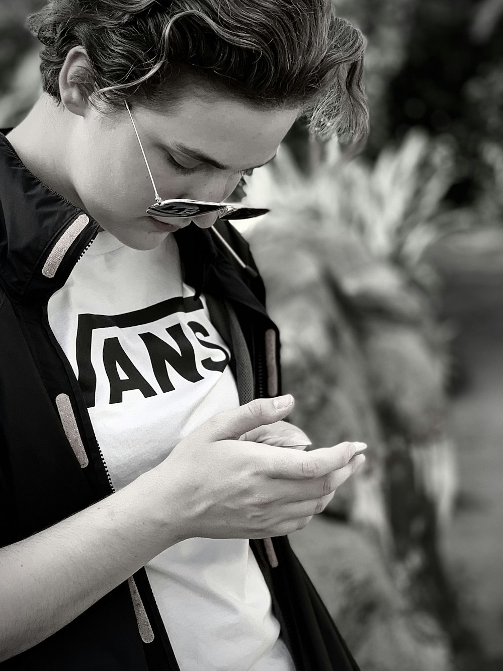 woman in black and white shirt holding smartphone