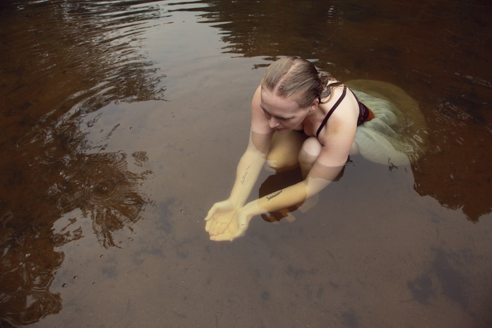 woman in black bikini kneeling on water