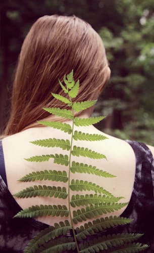 woman in black and white tank top with green leaf on her back