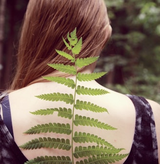 woman in black and white tank top with green leaf on her back