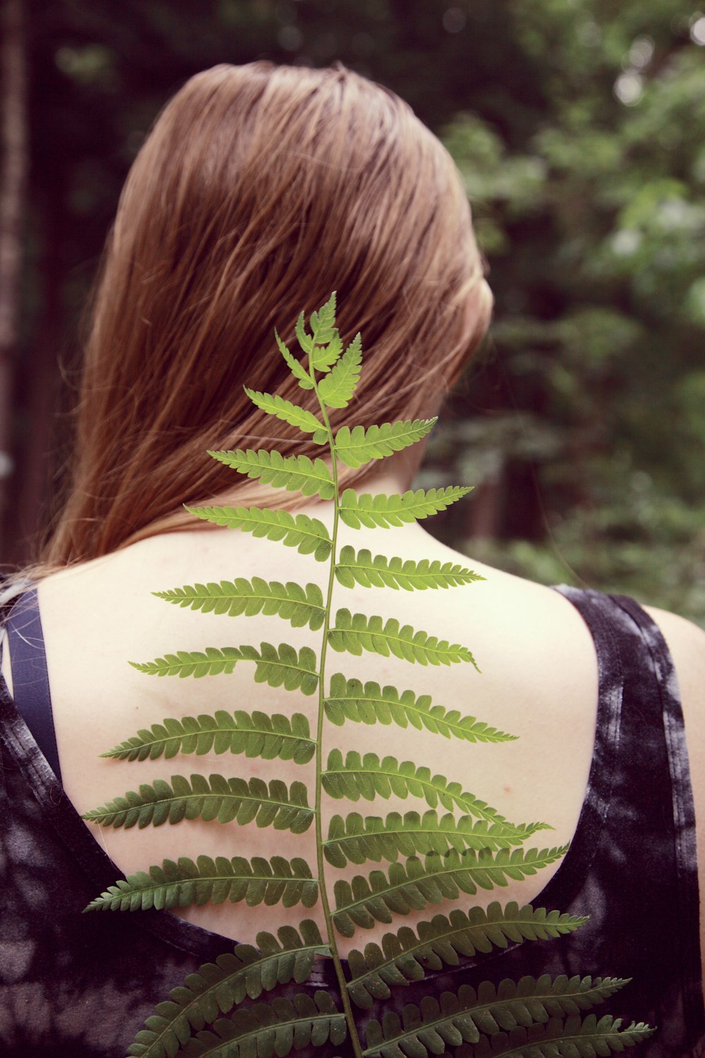 Frau in schwarz-weißem Tanktop mit grünem Blatt auf dem Rücken