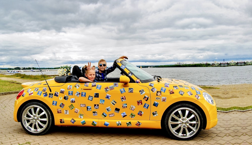 2 women riding yellow convertible car