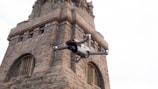 Close-up of a drone inspecting a modern building's roof for cleaning and conservation.