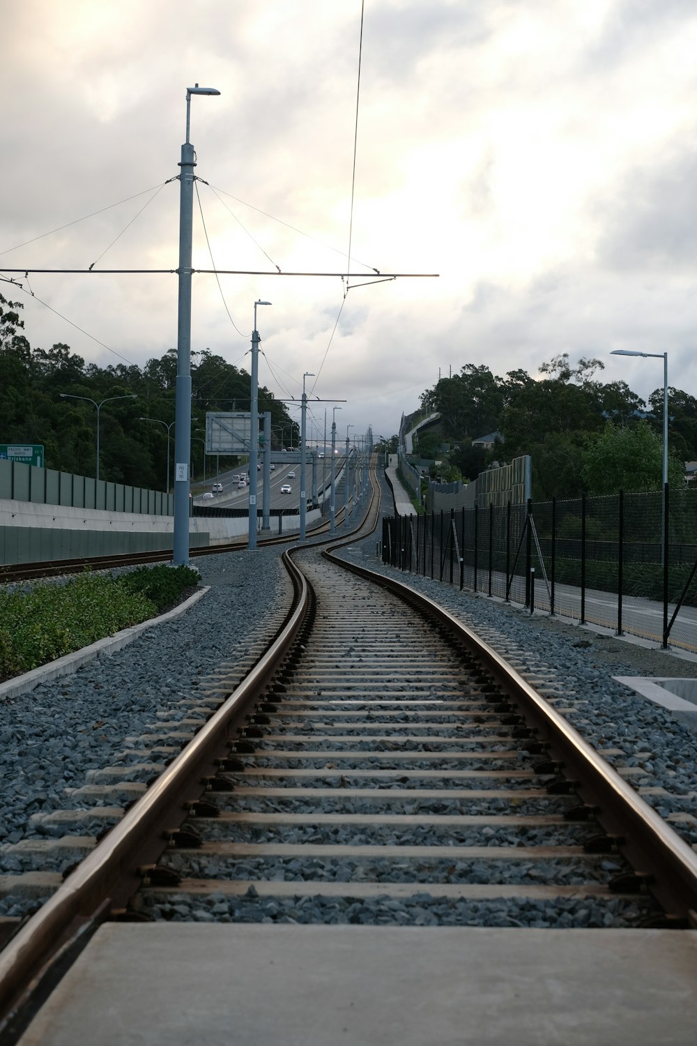 train rail under cloudy sky during daytime