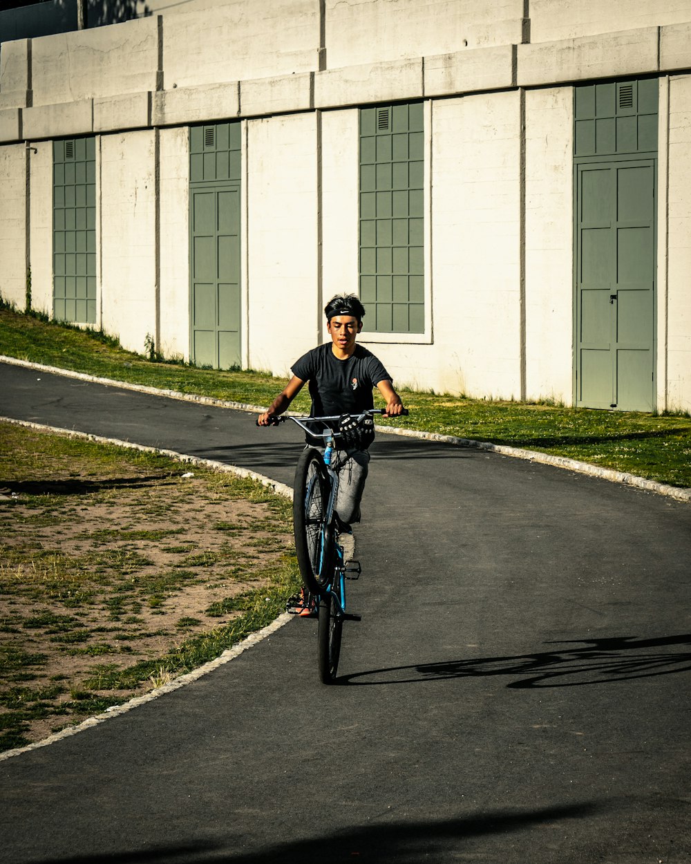 man in black jacket riding bicycle on road during daytime