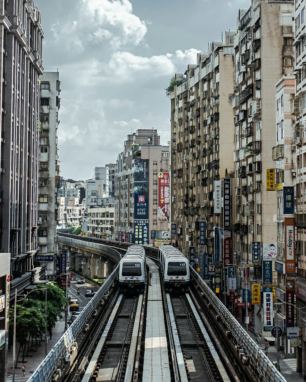 gray train on rail road between high rise buildings during daytime