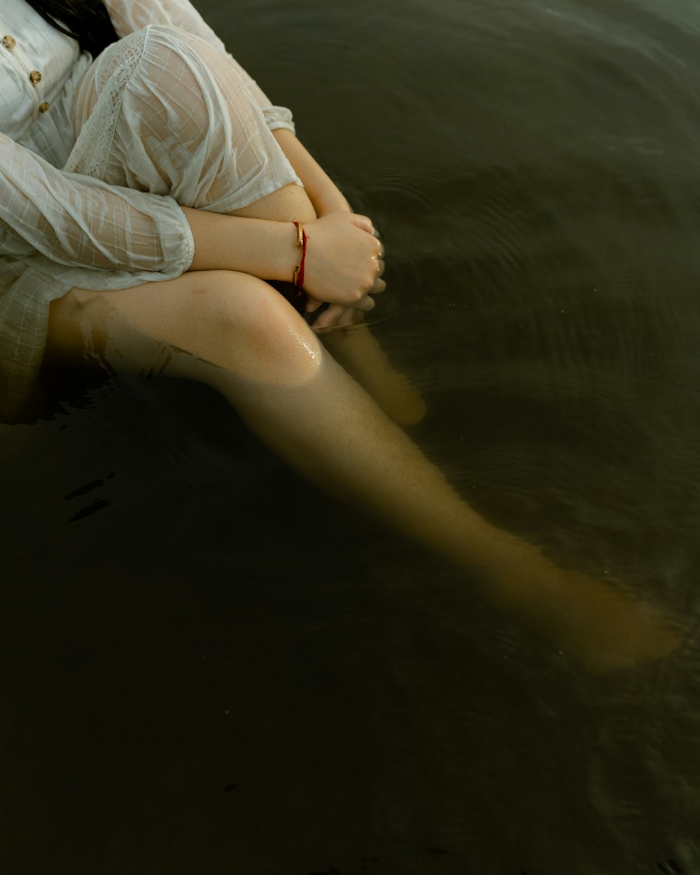 woman in blue denim shorts sitting on water