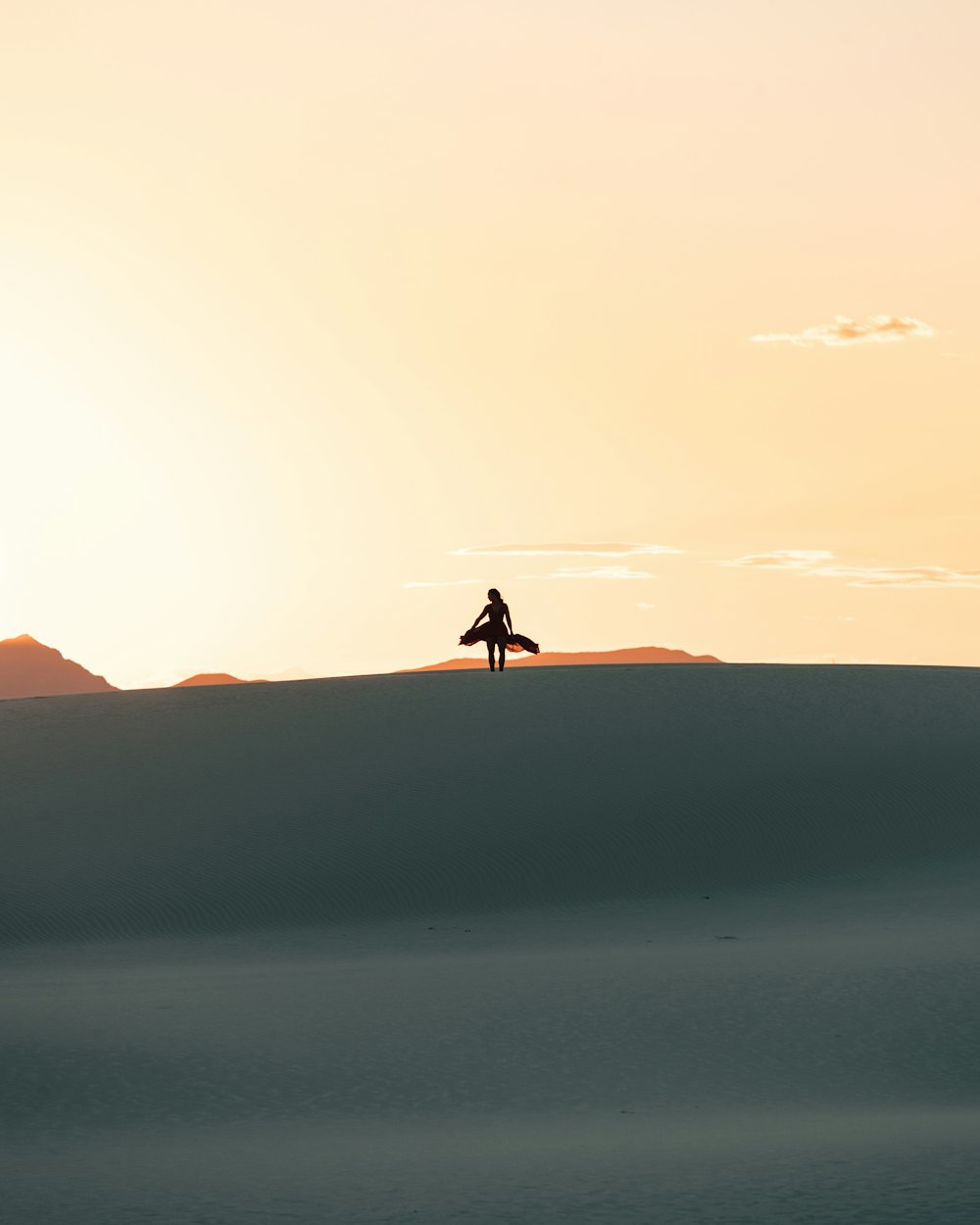 silhouette of person walking on desert during daytime