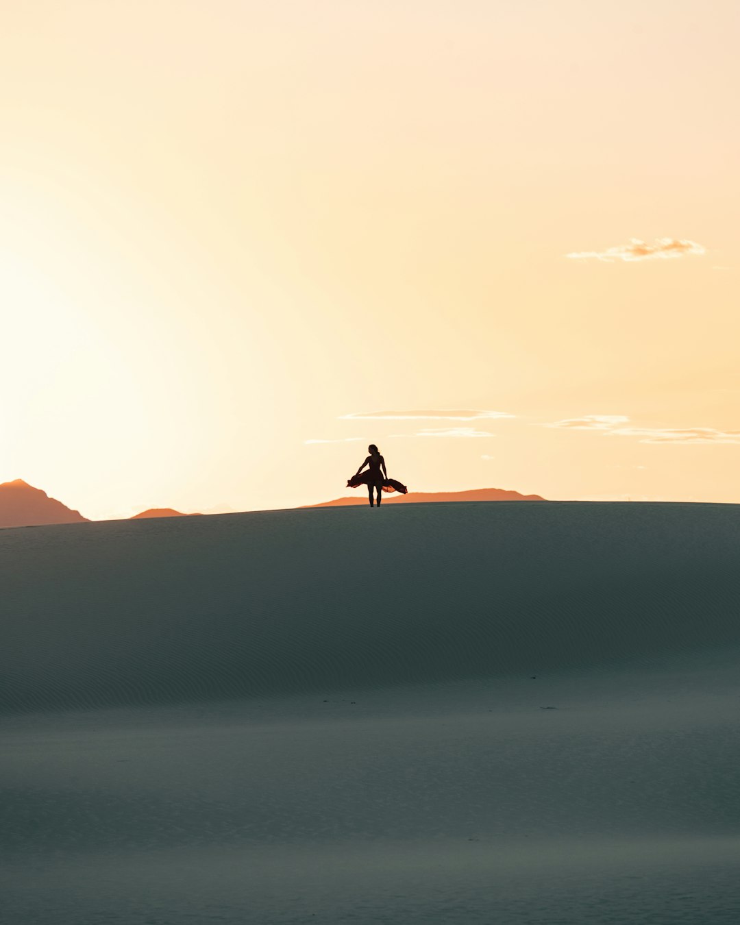 silhouette of person walking on desert during daytime