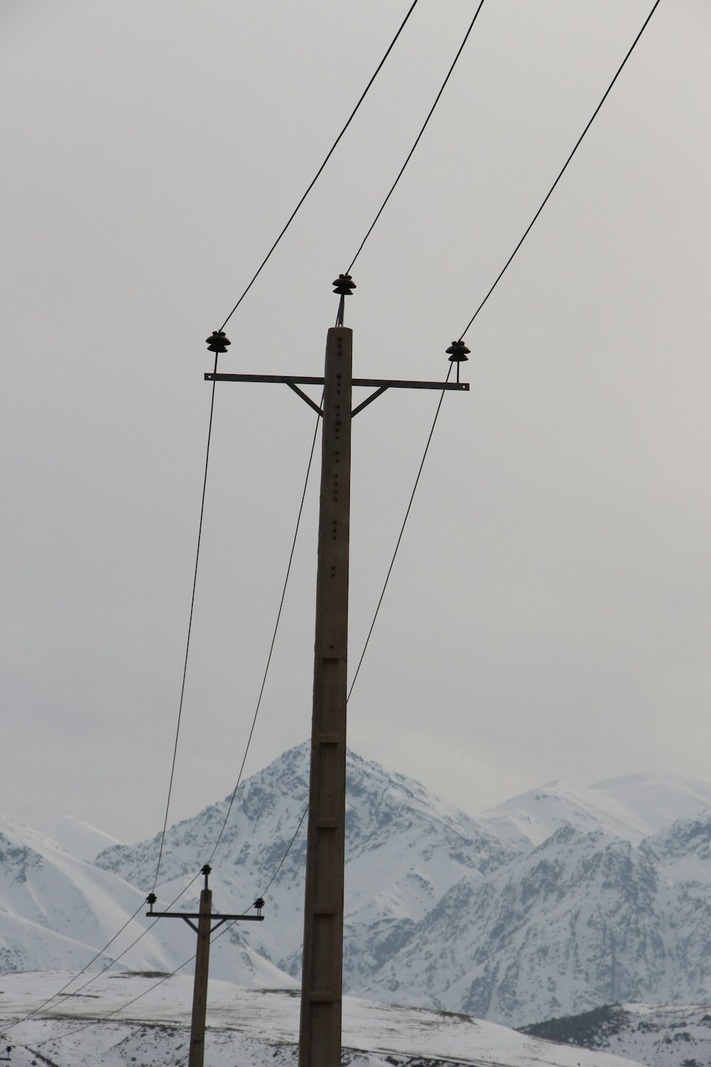 brown wooden post with snow covered mountain in distance