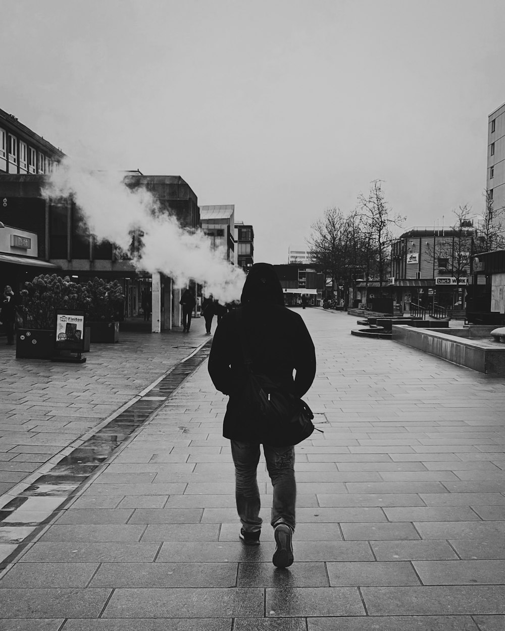 man in black jacket smoking cigarette in grayscale photography