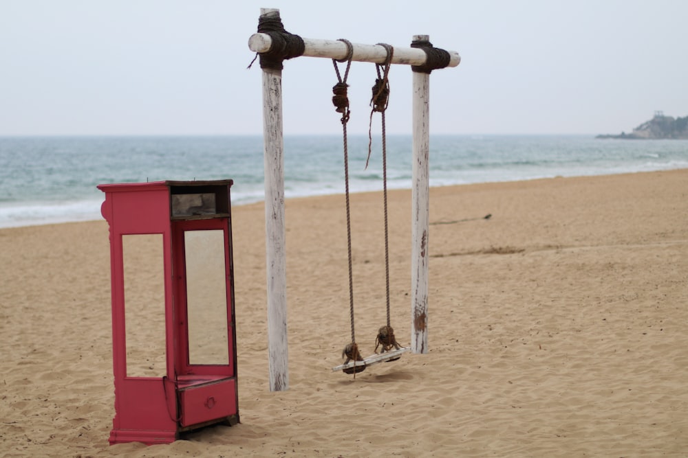 red and brown wooden post on beach during daytime