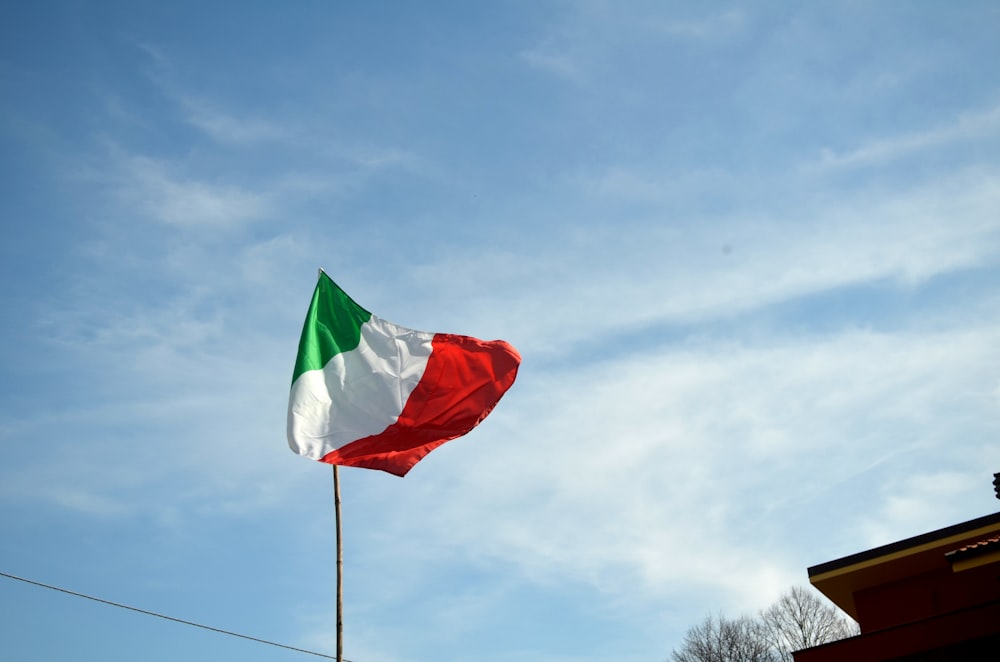 bandiera verde e rossa sotto il cielo blu durante il giorno