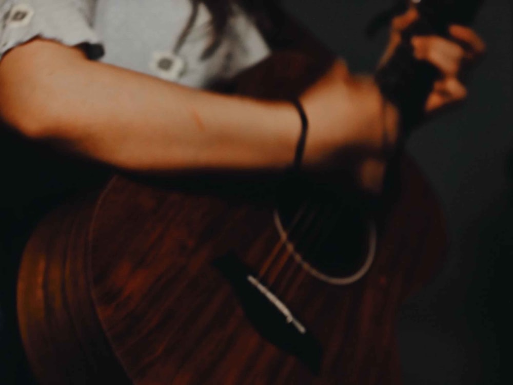 Mann im weißen T-Shirt spielt Gitarre