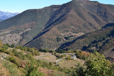 A scenic road trip view featuring winding roads and lush green hills.
