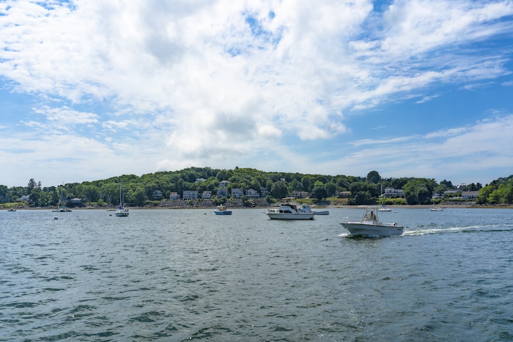 white boat on sea under blue sky and white clouds during daytime