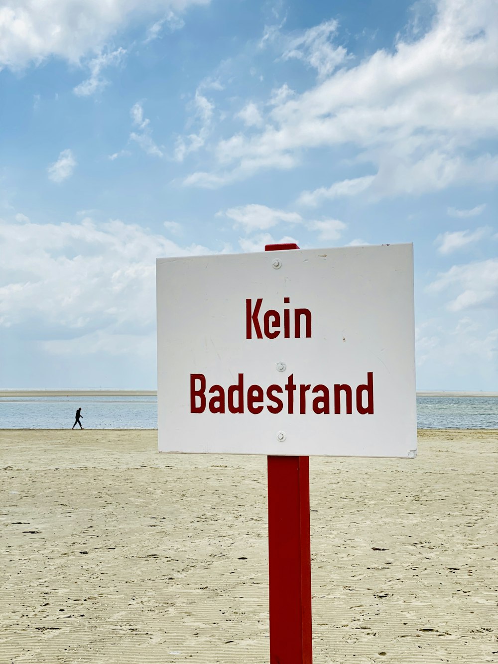 white and red no smoking sign on beach during daytime