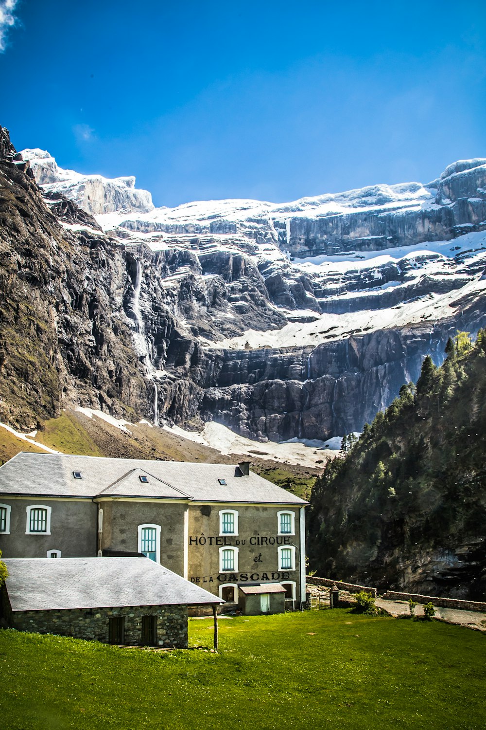 brown and white concrete building near gray rocky mountain under blue sky during daytime