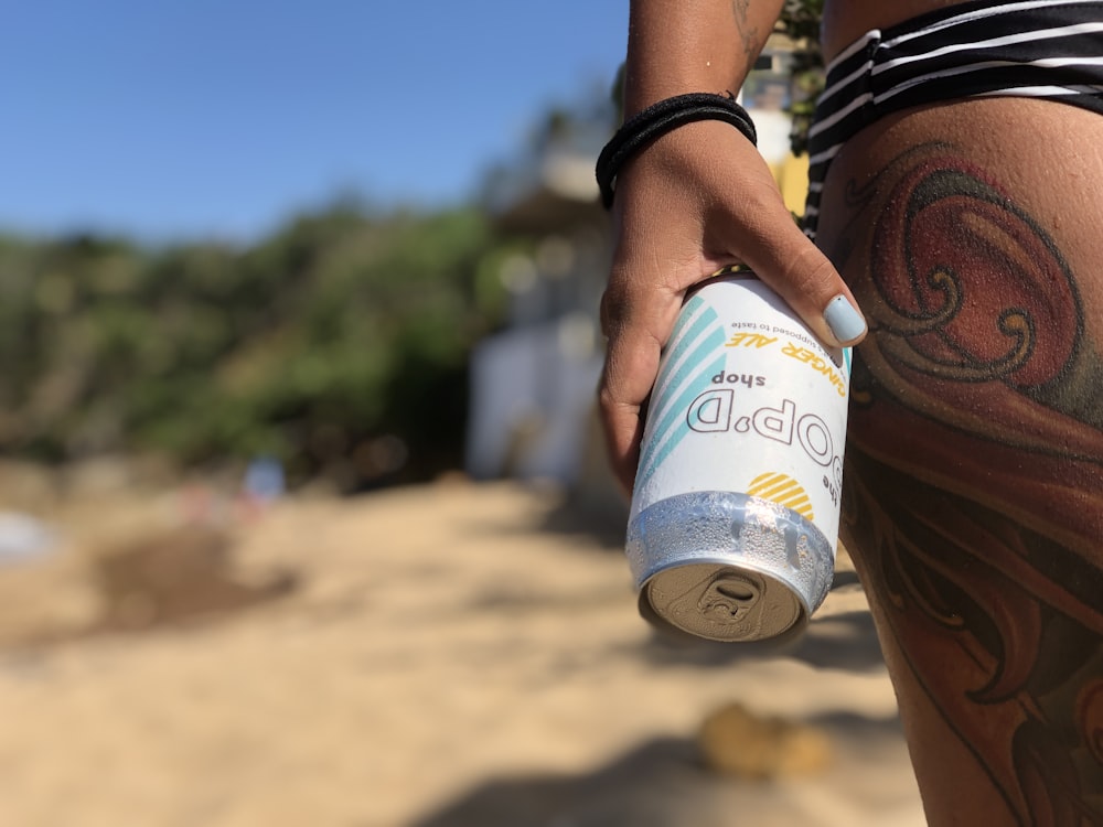 person holding white and blue disposable cup