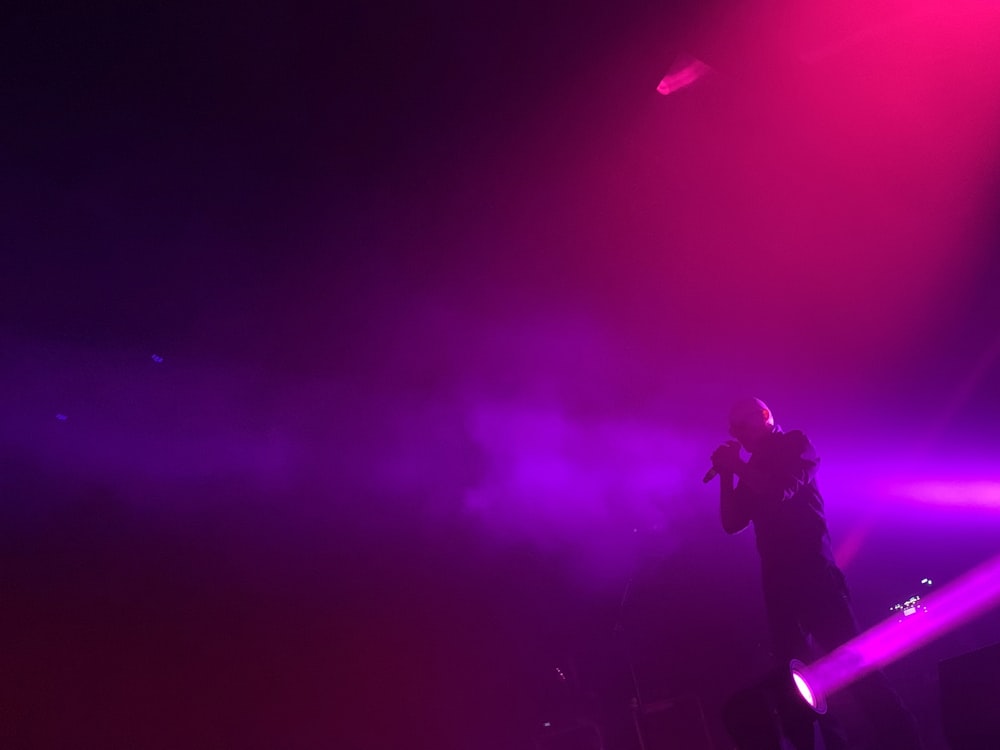 man in black jacket standing on stage