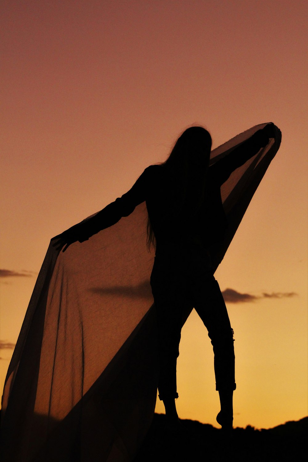 silhouette of woman covering her face with brown textile