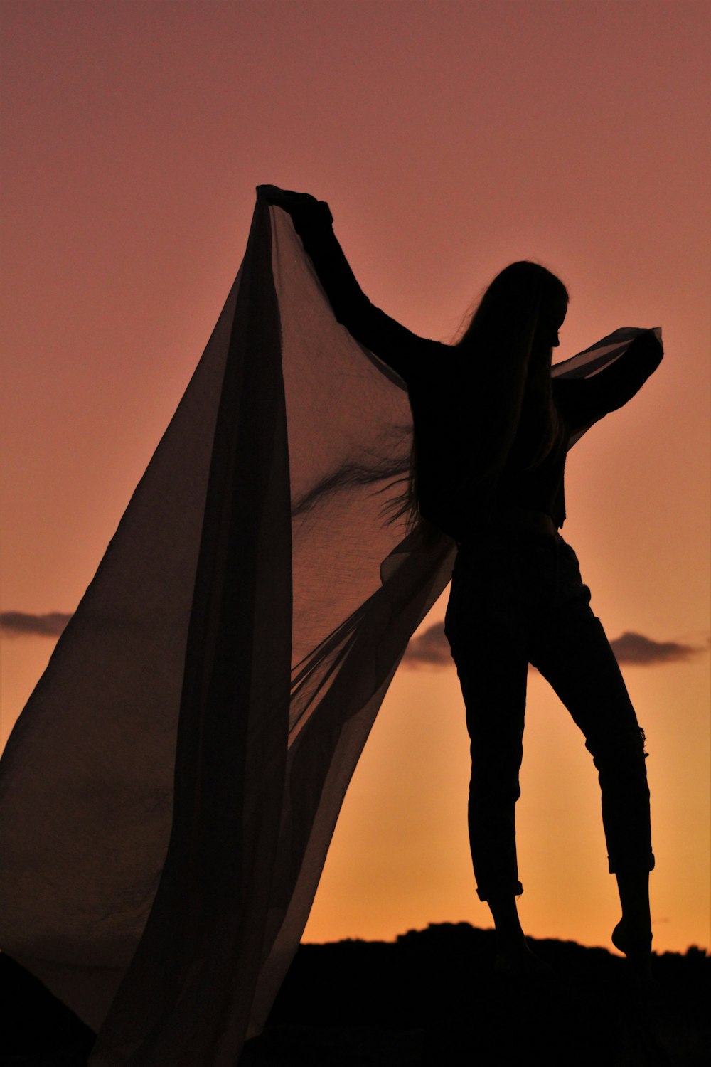 silhouette of woman holding textile