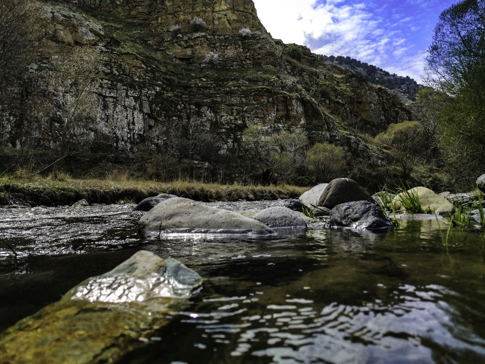 river between brown and green mountain under blue sky during daytime