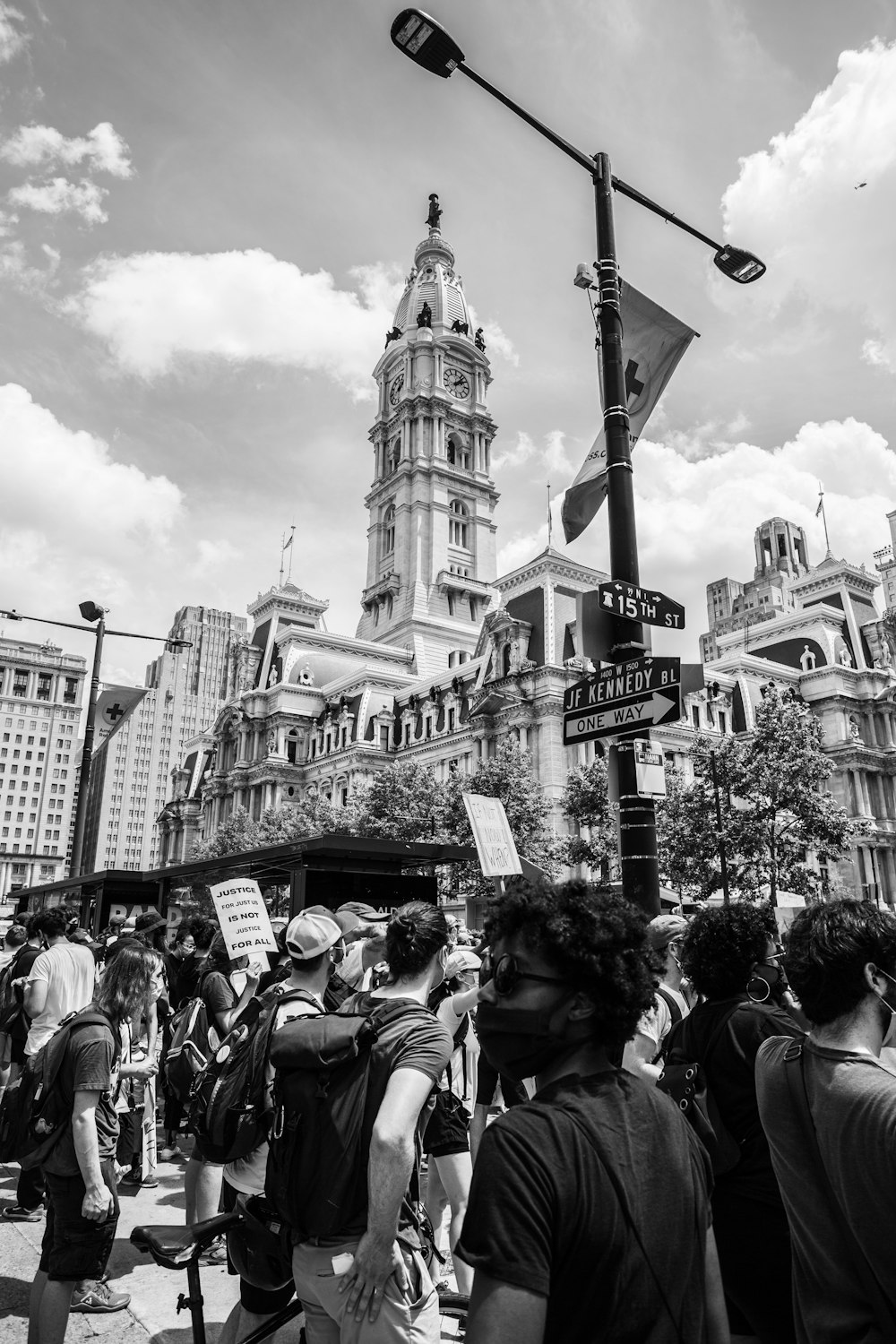 grayscale photo of people walking on street near building