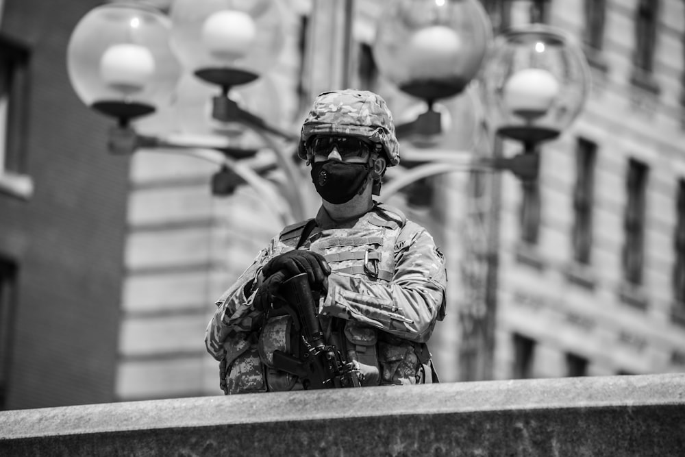 grayscale photo of man in camouflage uniform and helmet
