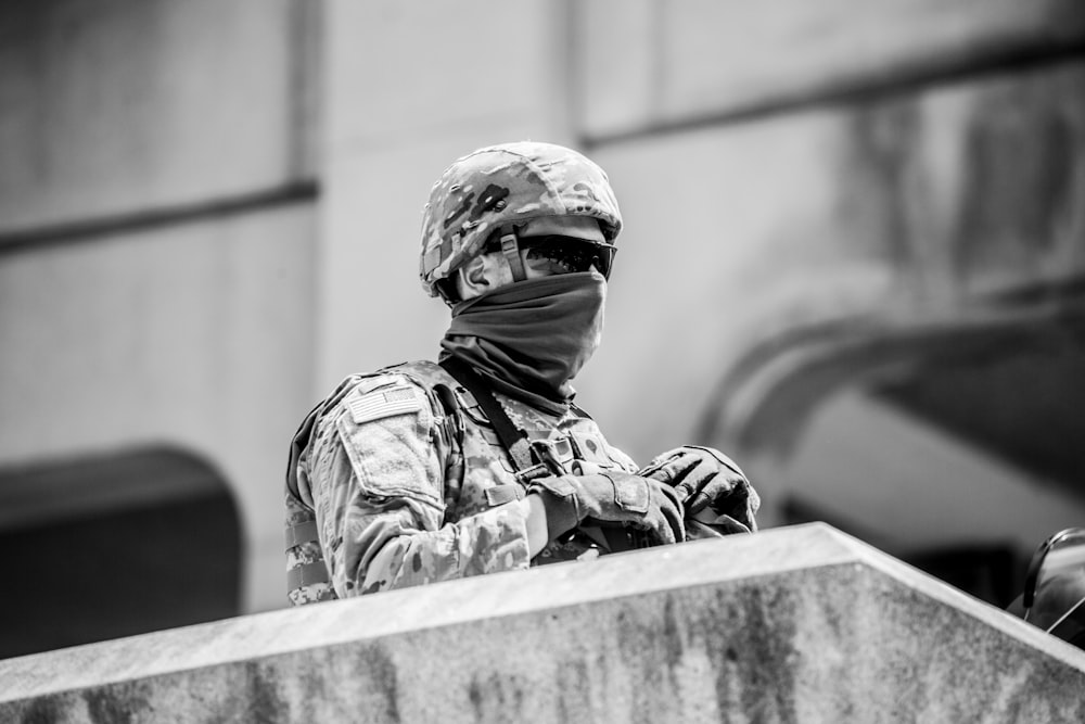 grayscale photo of man in camouflage uniform