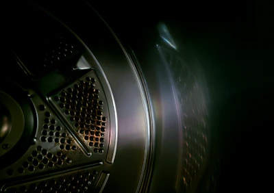 A close-up of a sparkling clean washing machine drum reflecting soft light.