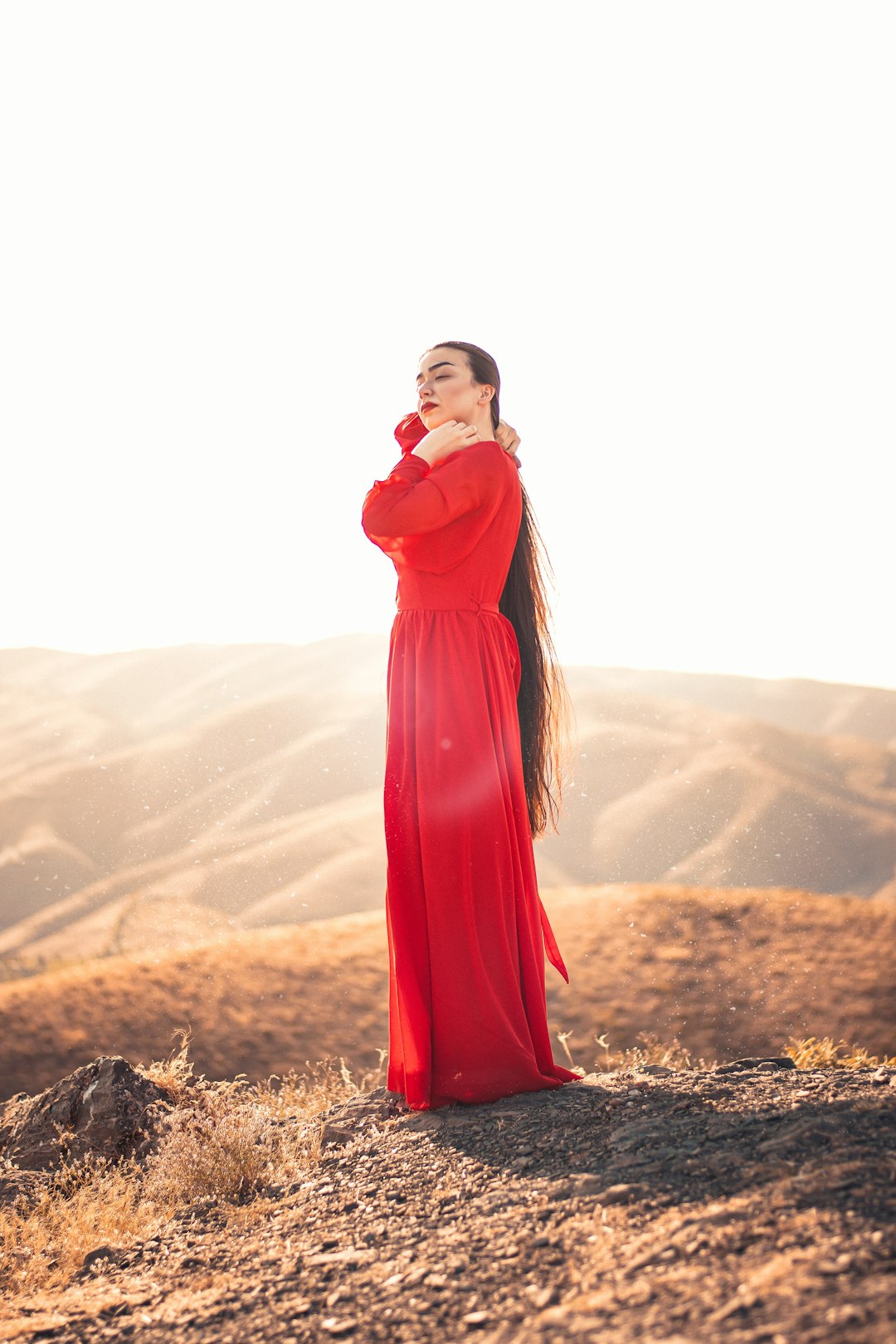 woman in red dress standing on brown grass field during daytime