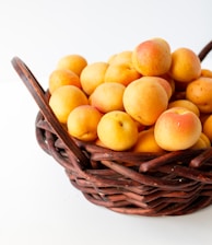 yellow round fruits on brown woven basket