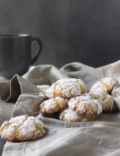 A stack of gluten-free cookies with a dusting of powdered sugar on a linen cloth