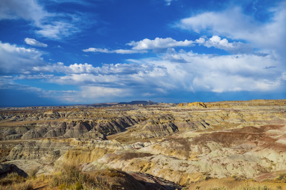 brown and green mountains under blue sky and white clouds during daytime