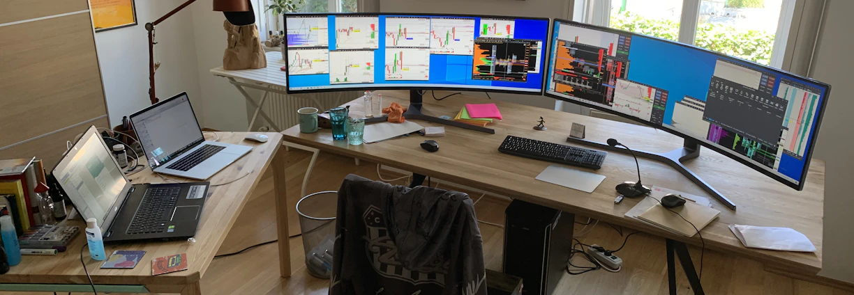 A modern real estate agent confidently analyzing data on multiple screens in a bright, minimalist office.