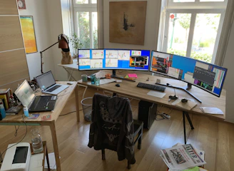 A modern real estate agent confidently analyzing data on multiple screens in a bright, minimalist office.