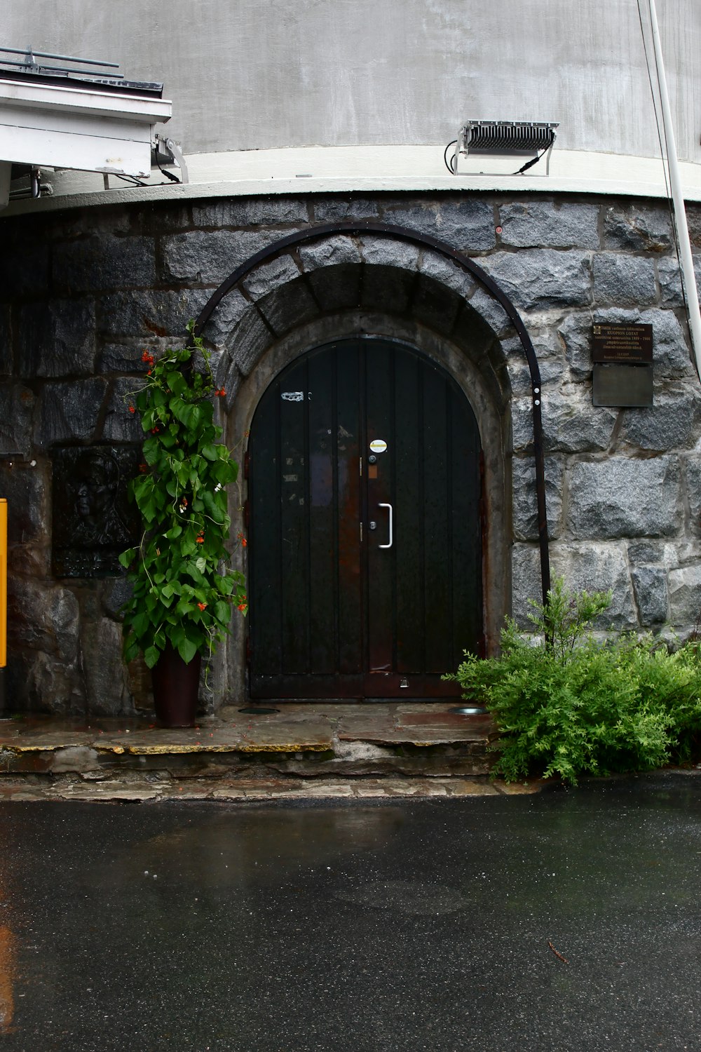 puerta de madera marrón sobre pared de hormigón gris